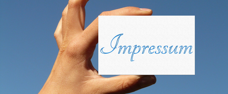 Hand mit einer Impressum Karte