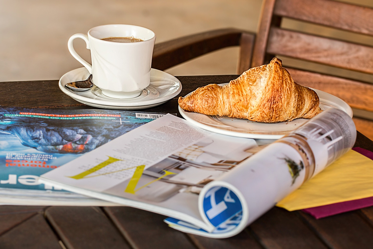 Kaffee, Snack und Zeitschrift auf der Terrasse