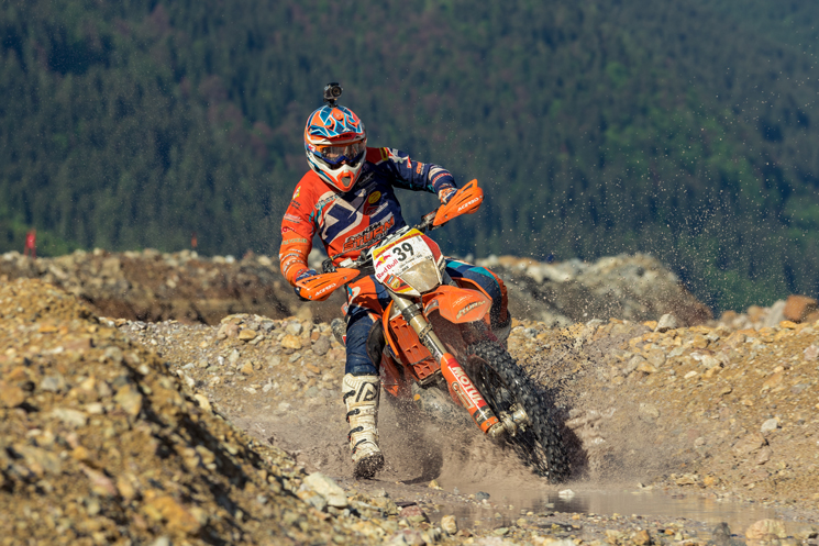 Freund fährt beim Enduro Rennen durch eine Pfütze