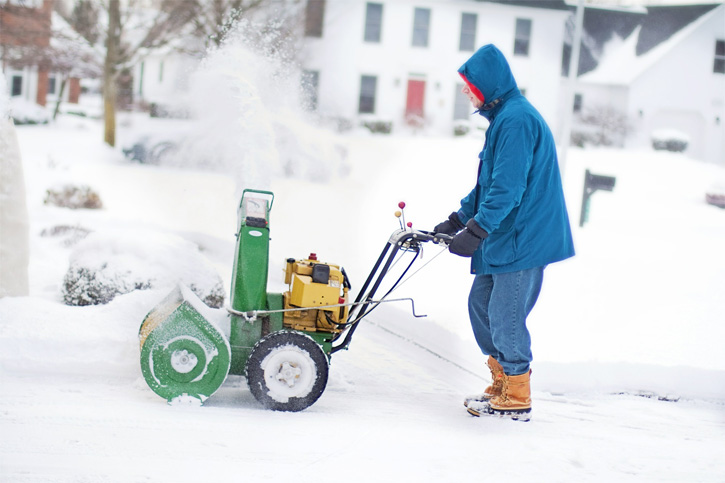 Ein Herr fräst seinen Weg im Winter.