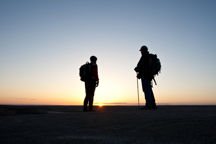 Personen die dem Sonnenuntergang entgegenblicken